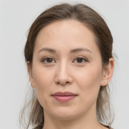 Joyful white young-adult female with medium  brown hair and grey eyes