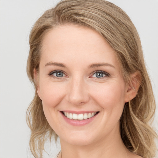 Joyful white young-adult female with medium  brown hair and blue eyes