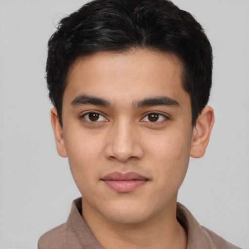 Joyful latino young-adult male with short  black hair and brown eyes