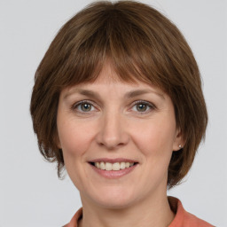 Joyful white adult female with medium  brown hair and grey eyes