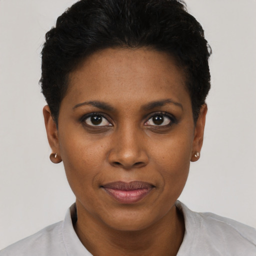 Joyful black young-adult female with short  black hair and brown eyes