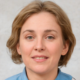 Joyful white young-adult female with medium  brown hair and blue eyes