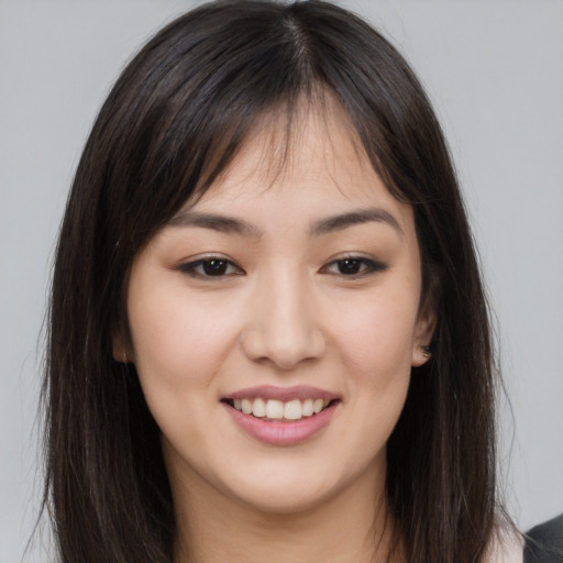 Joyful asian young-adult female with long  brown hair and brown eyes