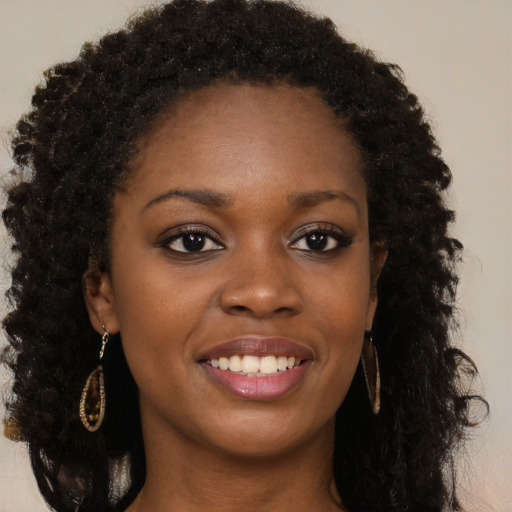 Joyful black young-adult female with long  brown hair and brown eyes