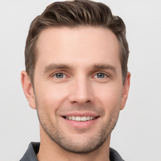 Joyful white young-adult male with short  brown hair and grey eyes