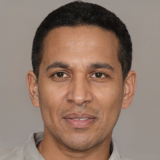 Joyful latino adult male with short  black hair and brown eyes