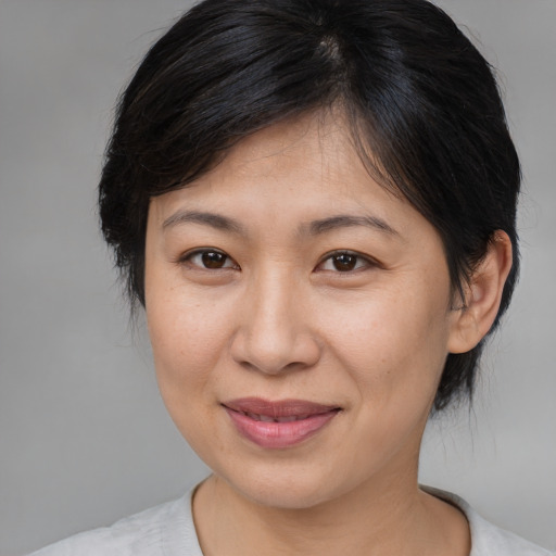 Joyful asian adult female with medium  brown hair and brown eyes