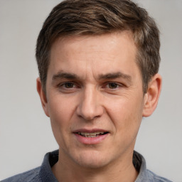 Joyful white young-adult male with short  brown hair and grey eyes