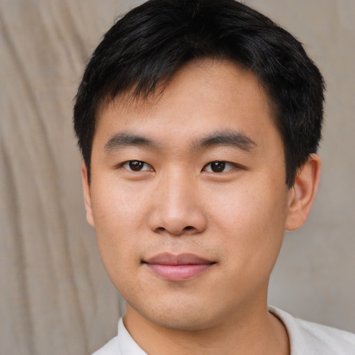 Joyful asian young-adult male with short  black hair and brown eyes