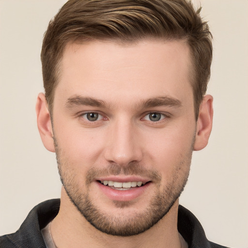 Joyful white young-adult male with short  brown hair and grey eyes