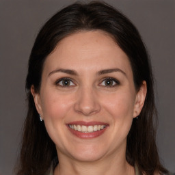 Joyful white adult female with long  brown hair and brown eyes