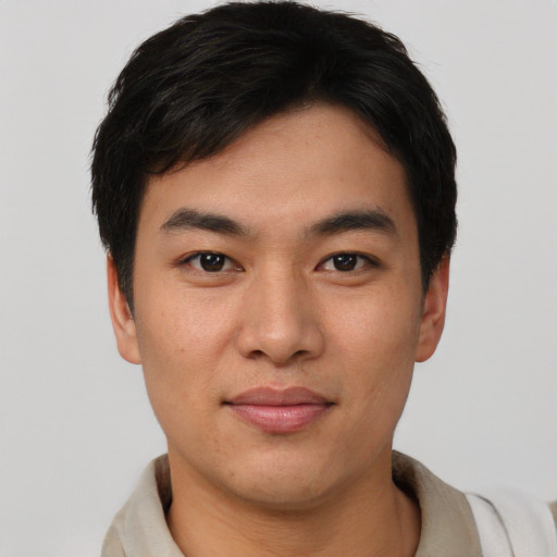 Joyful asian young-adult male with short  black hair and brown eyes