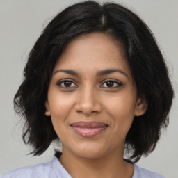 Joyful black young-adult female with medium  brown hair and brown eyes