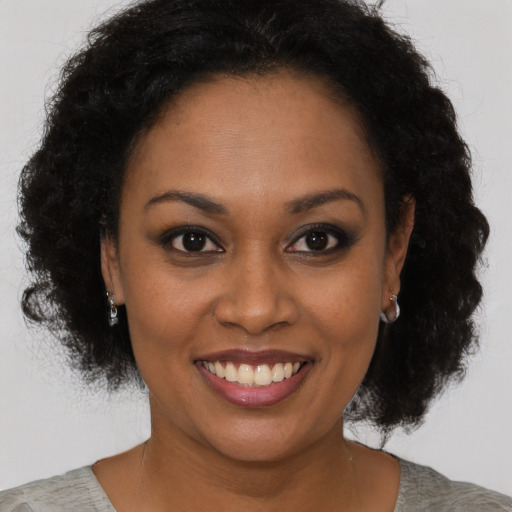 Joyful black young-adult female with short  brown hair and brown eyes
