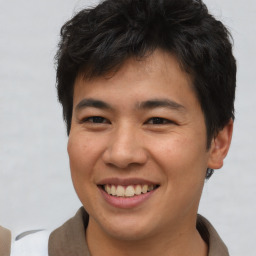 Joyful asian young-adult male with short  brown hair and brown eyes