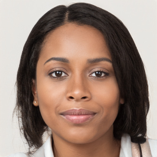 Joyful black young-adult female with long  black hair and brown eyes