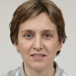 Joyful white adult female with medium  brown hair and grey eyes