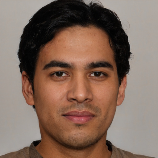 Joyful latino young-adult male with short  black hair and brown eyes