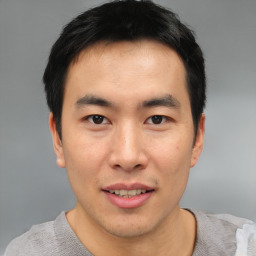 Joyful asian young-adult male with short  black hair and brown eyes