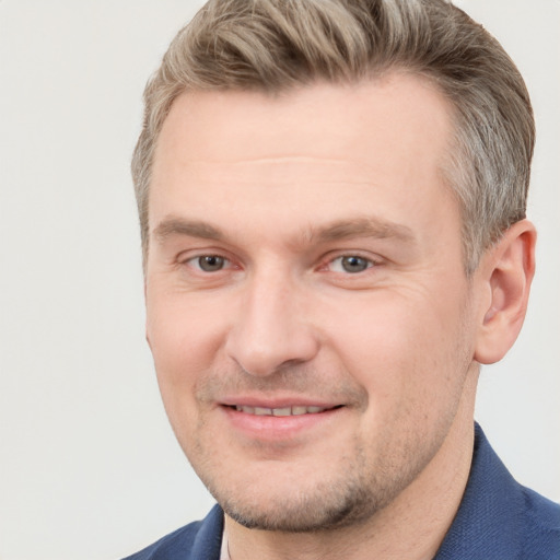 Joyful white adult male with short  brown hair and blue eyes