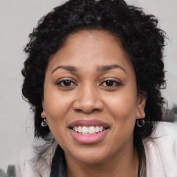 Joyful black young-adult female with long  brown hair and brown eyes