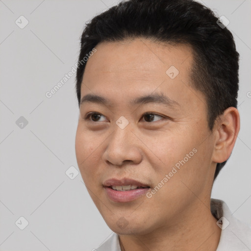 Joyful asian young-adult male with short  black hair and brown eyes