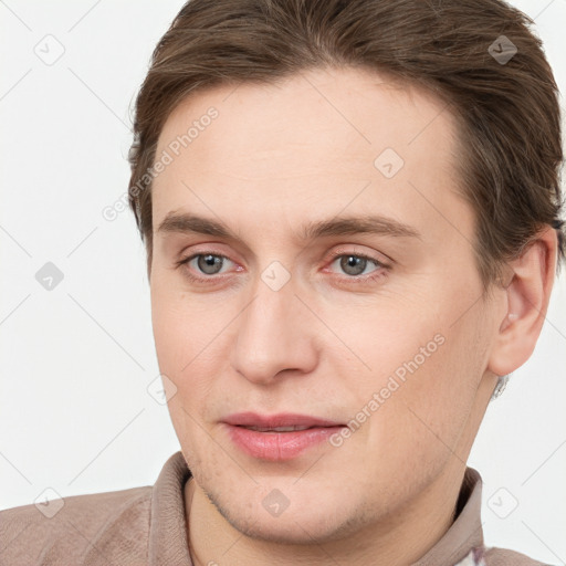 Joyful white young-adult male with short  brown hair and grey eyes