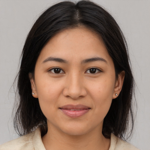 Joyful latino young-adult female with medium  brown hair and brown eyes