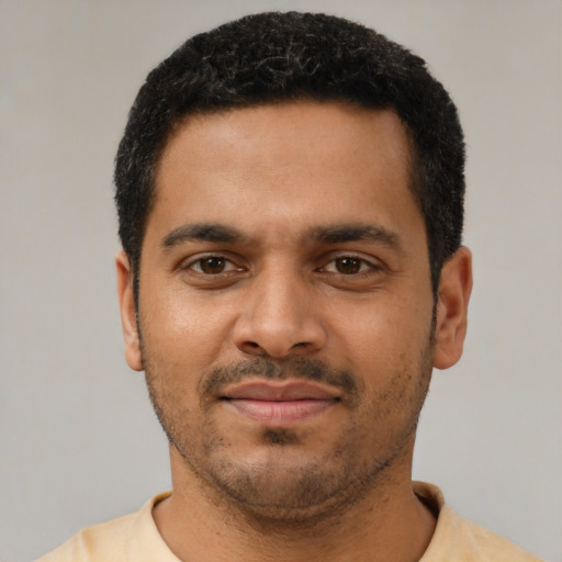 Joyful latino young-adult male with short  black hair and brown eyes