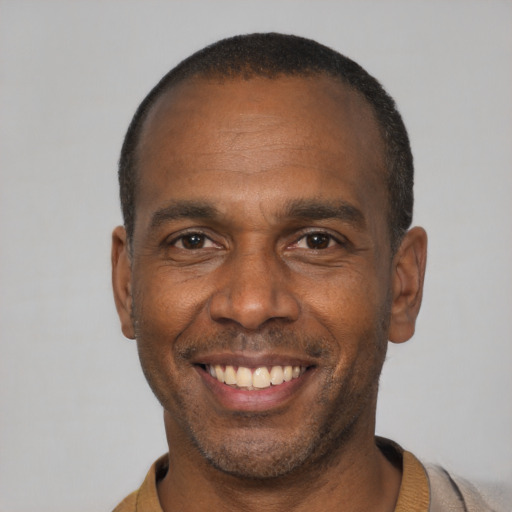 Joyful black adult male with short  black hair and brown eyes
