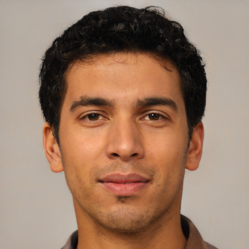 Joyful latino young-adult male with short  brown hair and brown eyes