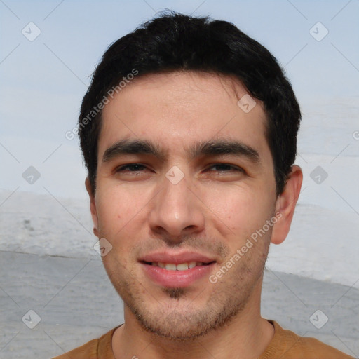 Joyful white young-adult male with short  black hair and brown eyes