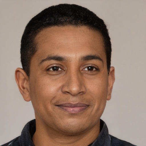 Joyful black adult male with short  black hair and brown eyes