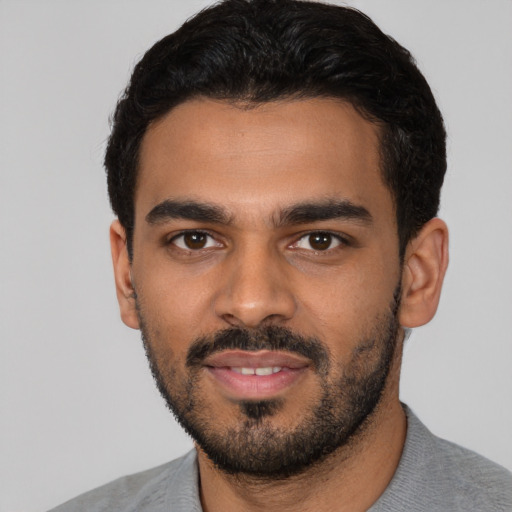 Joyful latino young-adult male with short  black hair and brown eyes
