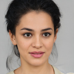 Joyful latino young-adult female with medium  brown hair and brown eyes