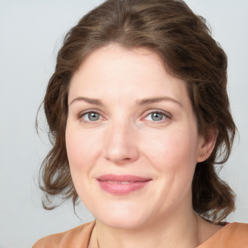 Joyful white young-adult female with medium  brown hair and green eyes