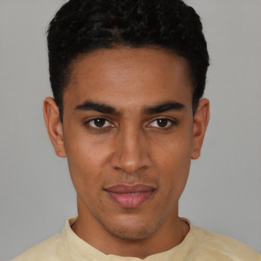 Joyful latino young-adult male with short  brown hair and brown eyes