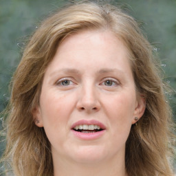 Joyful white adult female with long  brown hair and grey eyes