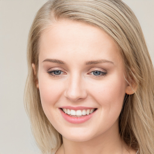 Joyful white young-adult female with long  brown hair and blue eyes