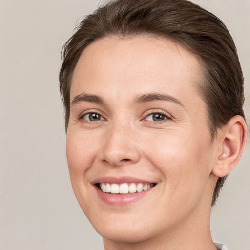 Joyful white young-adult female with short  brown hair and grey eyes