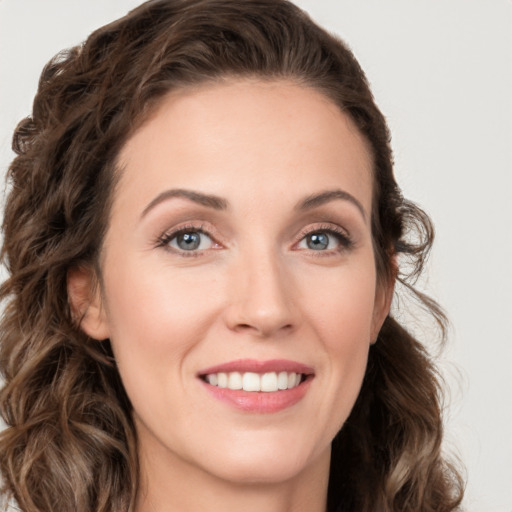 Joyful white young-adult female with long  brown hair and green eyes