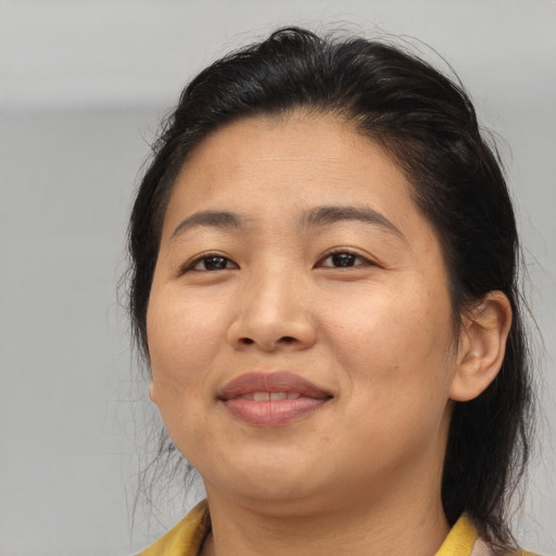 Joyful asian adult female with medium  brown hair and brown eyes