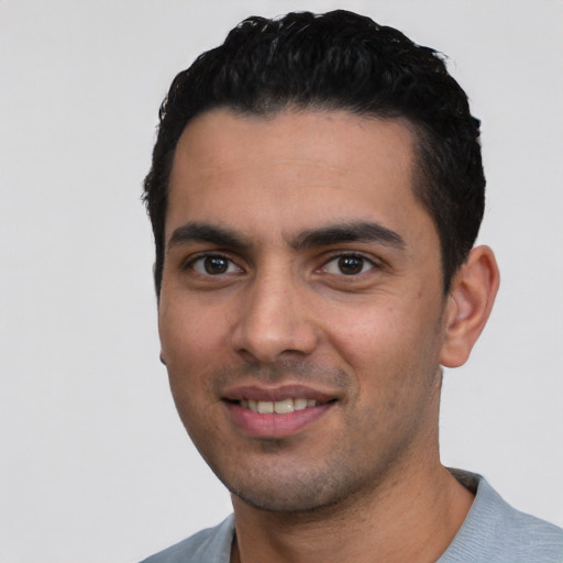 Joyful white young-adult male with short  black hair and brown eyes