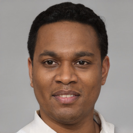 Joyful black young-adult male with short  black hair and brown eyes