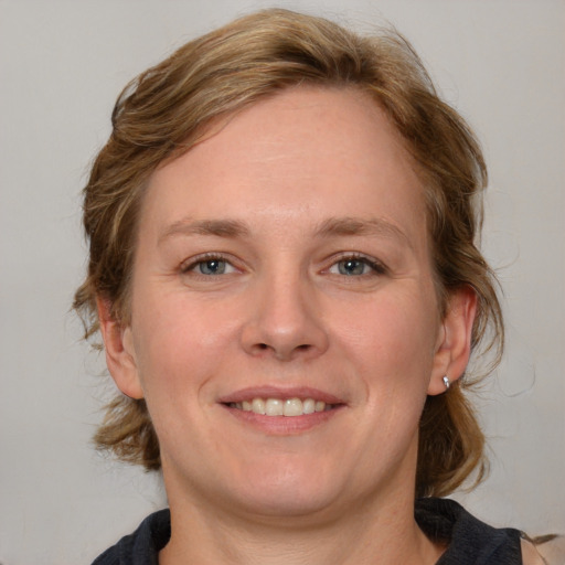 Joyful white adult female with medium  brown hair and blue eyes