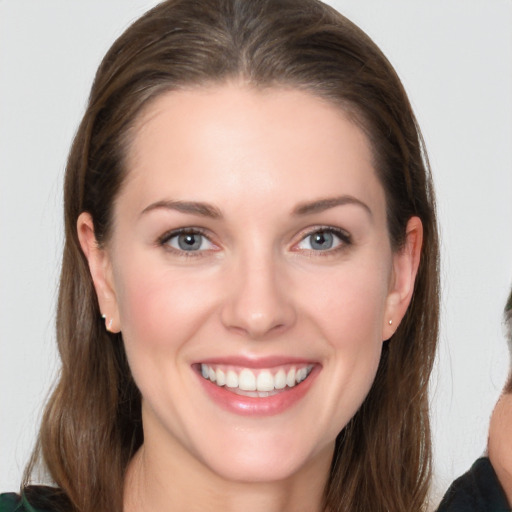 Joyful white young-adult female with long  brown hair and grey eyes