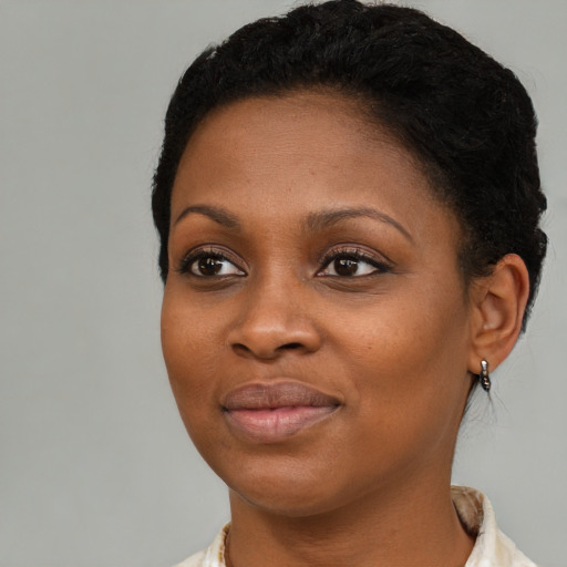 Joyful black young-adult female with short  brown hair and brown eyes