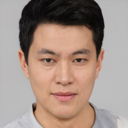 Joyful asian young-adult male with short  black hair and brown eyes