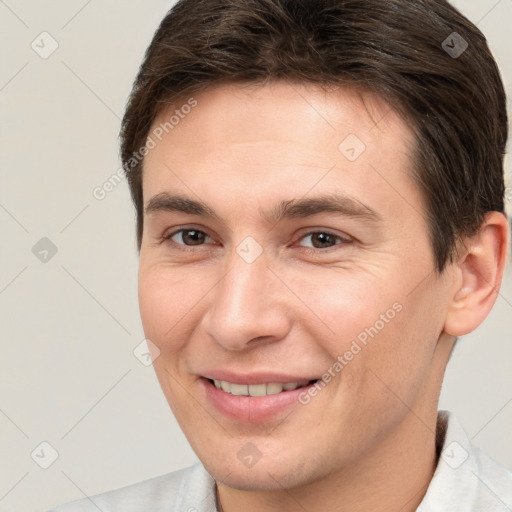 Joyful white young-adult male with short  brown hair and brown eyes