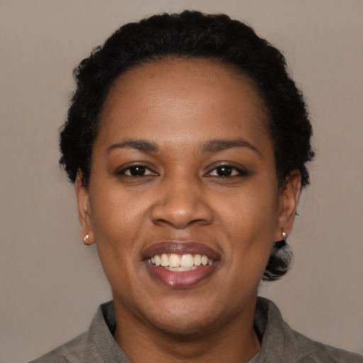 Joyful black adult female with short  black hair and brown eyes